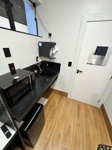 a kitchen with a counter top with a microwave at 2Studio no centro, aconchegante no coração da cidade, UFLA - UNILAVRAS in Lavras