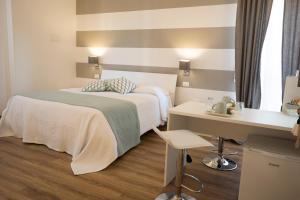 サルザーナにあるSuite Simonettaのベッドとデスクが備わるホテルルームです。