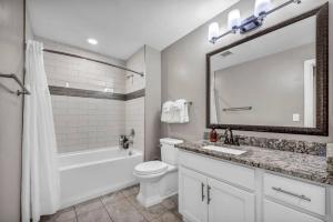 a bathroom with a sink and a toilet and a mirror at Upscale Downtown Loft | Parking • Gym in Cleveland +34 photos