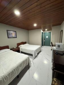 a bedroom with two beds and a tv in it at Burntwood Hotel and Restaurant in Thompson +2 photos