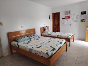 two twin beds in a room withthritisthritisthritisthritisthritisthritisthritisthritisthritis at Kathleens Vacation Place in Moalboal