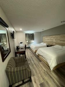 a hotel room with two beds and a chair at Burntwood Hotel and Restaurant in Thompson