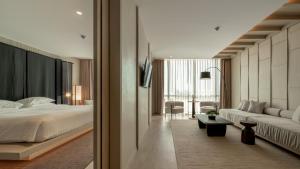 a bedroom with a bed and a living room at Grand Vista Hotel Chiangrai in Chiang Rai