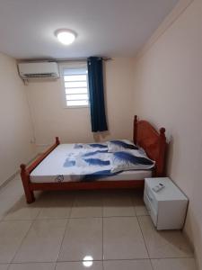 a bedroom with a bed and a window at Santa Marta in Rivière-Pilote +2 photos