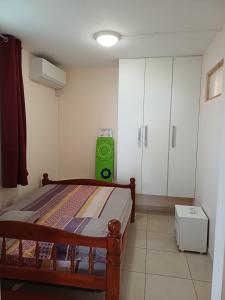 a bedroom with a bed and a green suitcase at Santa Marta in Rivière-Pilote