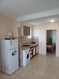 a kitchen with a refrigerator and a washing machine at Santa Marta in Rivière-Pilote