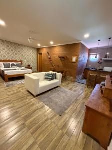 a living room with a white couch and a bed at Chácara Bora Bora in São Bento do Sapucaí