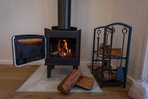 a wood stove with a fire in a room at Banjos Cabin Gippsland - Luxury Eco Stay w King Bed & Pond Valley Views in Seaton +122 photos
