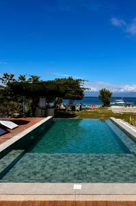 a swimming pool with a view of the ocean at Uzuri Kubo Huts in Moalboal