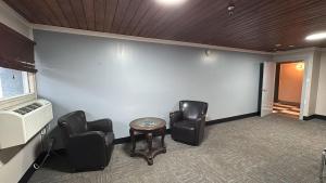 a waiting room with chairs and a table and a fan at Burntwood Hotel and Restaurant in Thompson