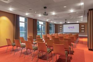 a conference room with chairs and a projection screen at Spark by Hilton Lyon Eurexpo in Genas