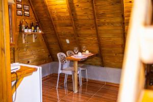 a small table and chairs in a room with wooden walls at Cabana Suiça 2 in Guaramiranga