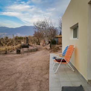 a chair and a grill in a yard with a dog at Departamento Guadalupe in Fiambalá
