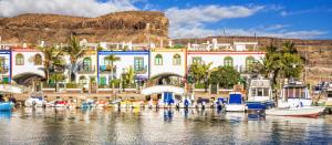 a group of boats are docked in a marina at Roca Mogán in Puerto de Mogán
