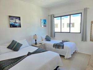 a hotel room with two beds and a window at Casa Havana Mid in Mérida