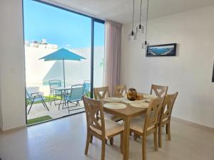 a dining room with a table and chairs and a patio at Casa Havana Mid in Mérida