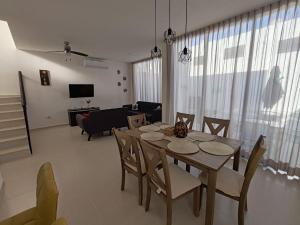 a dining room with a table and chairs and a living room at Casa Havana Mid in Mérida