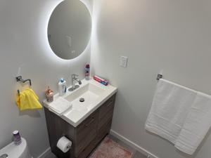 a bathroom with a sink and a mirror and a toilet at Urban Haven Suite in Winnipeg