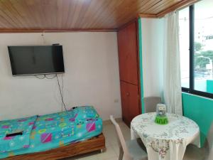 a bedroom with a bed and a table and a tv at Aventura inn 304 in Rodadero
