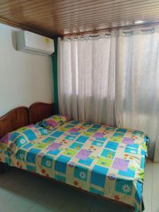 a small bed in a room with a window at Aventura inn 304 in Rodadero