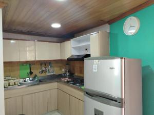 a kitchen with a stainless steel refrigerator and wooden cabinets at Aventura inn 304 in Rodadero