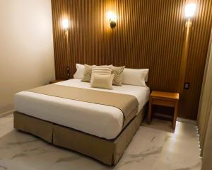 a bedroom with a large white bed with two pillows at Hotel JVD Inn - Tonalá Centro GDL in Guadalajara