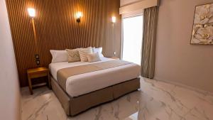 a bedroom with a large bed with a window at Hotel JVD Inn - Tonalá Centro GDL in Guadalajara