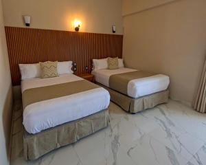 two beds in a hotel room with marble floors at Hotel JVD Inn - Tonalá Centro GDL in Guadalajara +19 photos