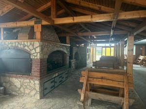 a stone fireplace with a television and a wooden bench at Motel Alibey in Bugojno
