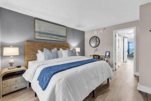 a bedroom with a large bed with a blue blanket at Last Chance Summer, Oceanfront Pools and Beach in Myrtle Beach +24 photos