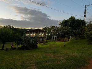 a house sitting on top of a lush green field at Cabañas El Macuco in Dos de Mayo