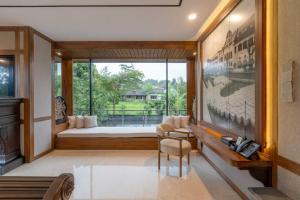 ein Schlafzimmer mit einem Bett und einem großen Fenster in der Unterkunft Intragama Villa in Puncak