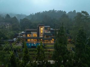 ein großes Gebäude mitten in einem Wald in der Unterkunft Intragama Villa in Puncak
