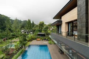 Außenansicht eines Hauses mit Swimmingpool in der Unterkunft Intragama Villa in Puncak