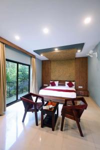 a bedroom with a bed and a table and chairs at Snow Drops Resort in Vythiri