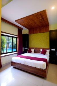 a bedroom with a large bed and a window at Snow Drops Resort in Vythiri