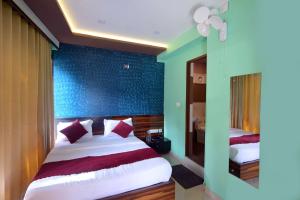 a bedroom with a bed and a blue wall at Snow Drops Resort in Vythiri