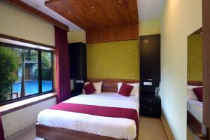 a bedroom with a bed and a large window at Snow Drops Resort in Vythiri
