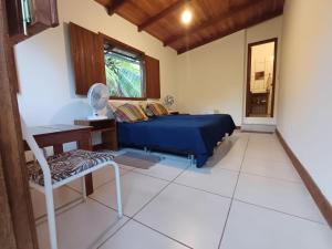 a living room with a blue bed and a table at Suíte Colibri - Centro de Barra Grande in Marau