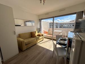 a living room with a couch and a table at Studio cabine à Sète avec terrasse et climatisation - FR-1-338-106 in Sète