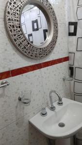 a bathroom with a sink and a mirror on the wall at Cabañas Arelí in Santa María +4 photos