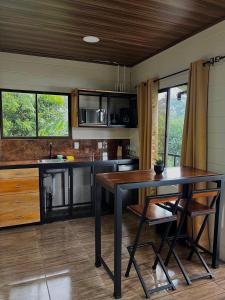 a kitchen with a table and chairs in a room at La cabaña del Colibrí in Bijagua +20 photos