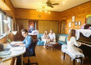 a group of people sitting in a living room with a piano at Super Henro Inn in Nahari +72 photos