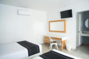 a bedroom with a bed and a desk with a mirror at Hotel La Siesta, Gomez Palacio in Gómez Palacio