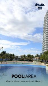 a view of a pool at a beach with a building at Studio B23 Azure North in San Fernando