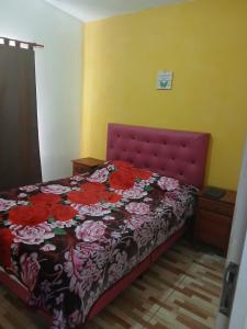 a bedroom with a bed with a red head board at Cabañas Arelí in Santa María