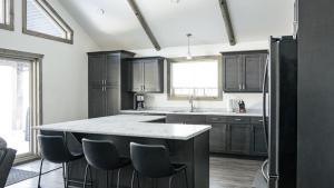 a kitchen with black cabinets and a large island at Elk Horn Cabin Rental in Valemount