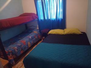 a bedroom with two beds and a window at Cabañas Arelí in Santa María