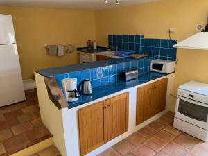 a kitchen with a blue tiled counter top at Mas de la clue - 4 personnes in Figanières