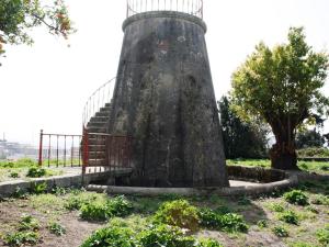 a lighthouse in a field with a fence at Pedra Iberica in Porto